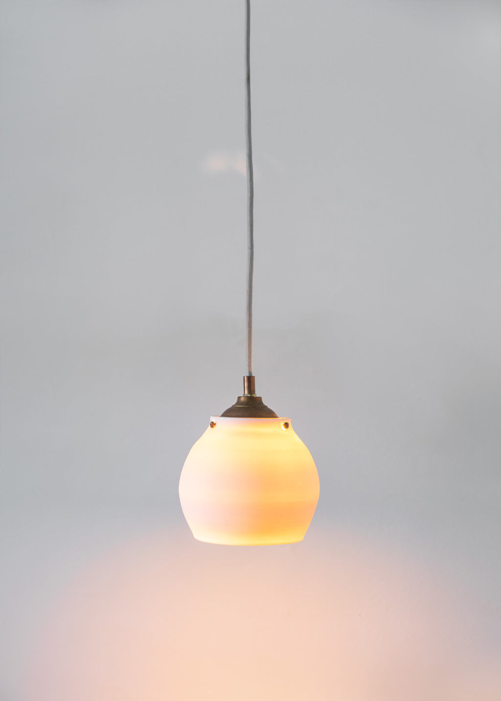 Wheel thrown pendant lamp, handmade from translucent porcelaine. All hardware is solid brass.Lampe suspendue en porcelaine translucide. Fixture en laiton. 