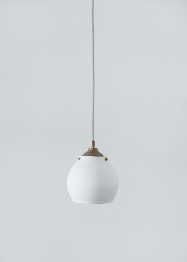 Wheel thrown pendant lamp, handmade from translucent porcelaine. All hardware is solid brass.Lampe suspendue en porcelaine translucide. Fixture en laiton. 