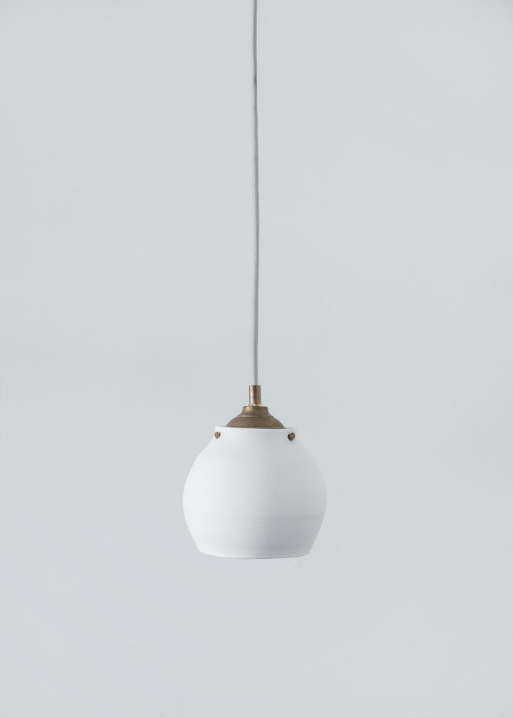 Wheel thrown pendant lamp, handmade from translucent porcelaine. All hardware is solid brass.Lampe suspendue en porcelaine translucide. Fixture en laiton. 