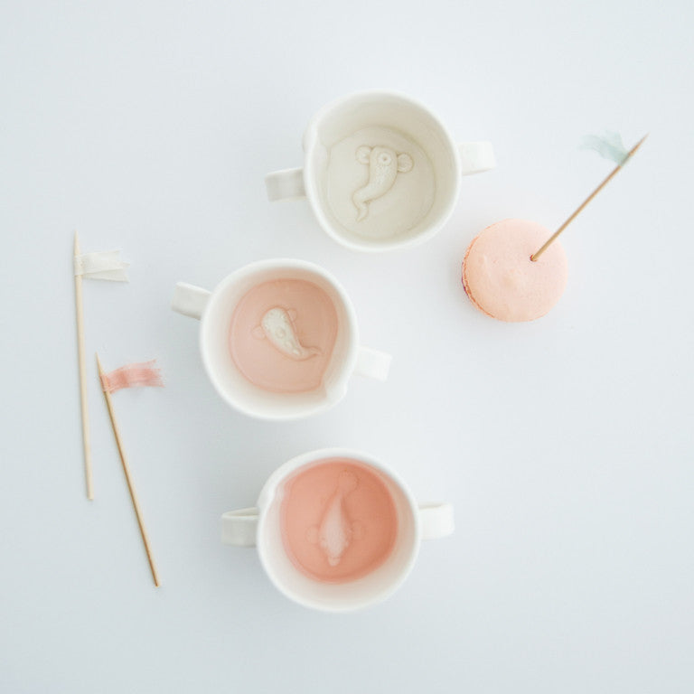 Our version of the classic kiddie cup! Each one has a little hand-made creature in the bottom. Notre version de la tasse enfantine classique! Au fond de chaque tasse se trouve une petite créature dessinée à la main.